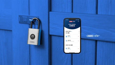 EVEROX One smart padlock on a wooden shed door and a smartphone with app screen in the foreground © ABUS